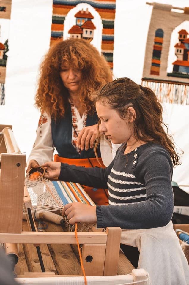 Slava Baldjieva giving a weaving lesson to a kid, 2019. Photo courtesy of Slava Baldjieva.